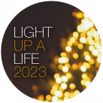Light Up A Life 2023 text alongside Christmas tree lights