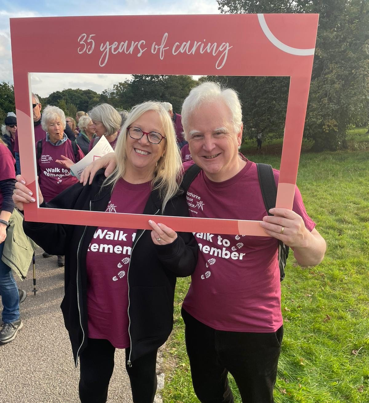 Richard Soulsby with his wife Alison smiling through our selfie frame which says '35 years of caring'